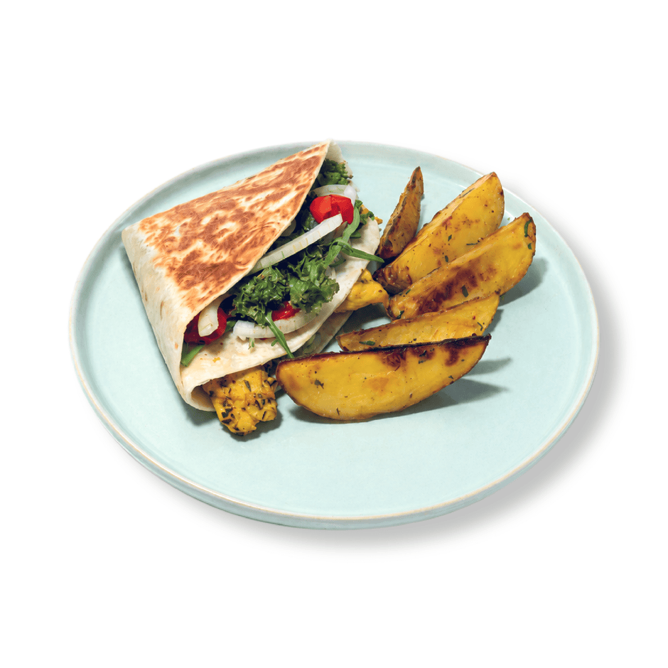 Close-up cross-section of a healthy chicken wrap revealing vibrant green guacamole layers and juicy seasoned chicken chunks