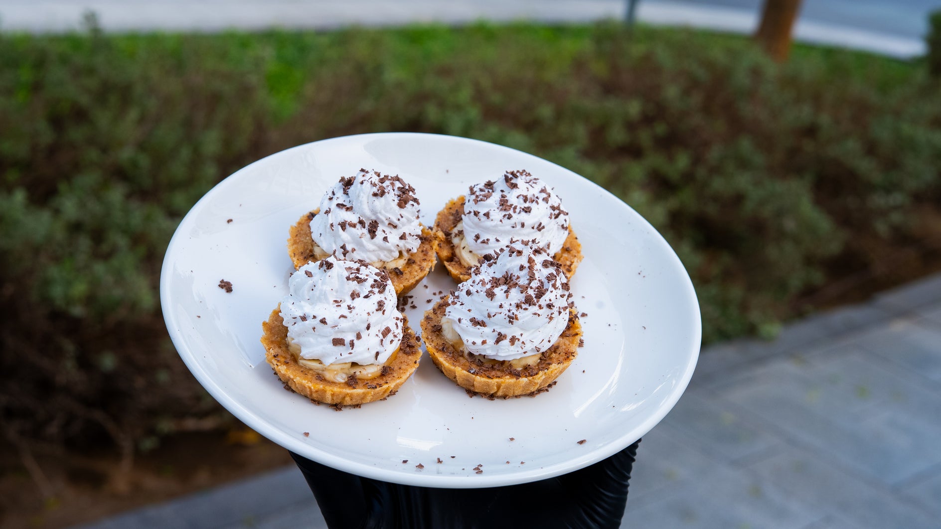 Indulgent mini cream tarts dusted with chocolate shavings served fresh at Bae-Kri café.