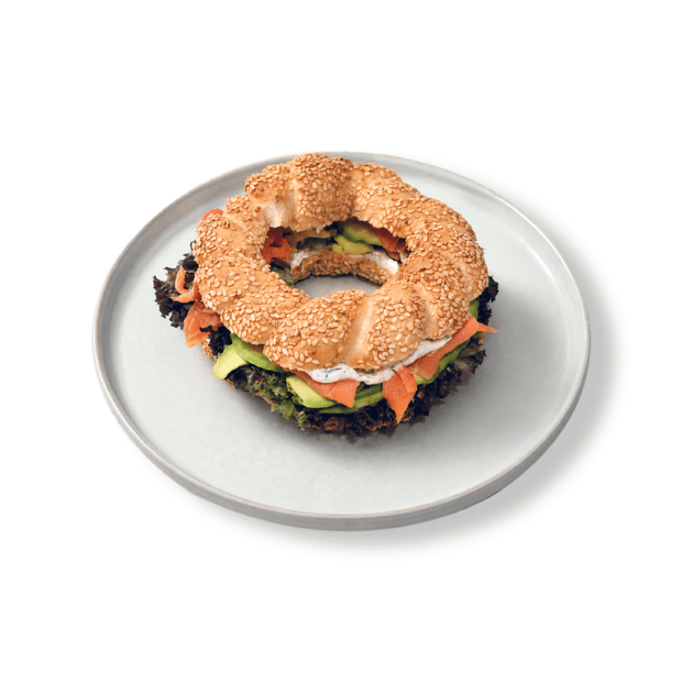 Toasted golden sesame crusted simit sandwich filled with premium smoked salmon ribbons cream cheese capers and dill